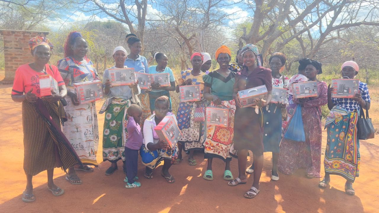 Women in Kitui County holding their new household solar lighting systems